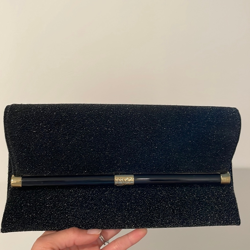 Diane von furstenburg black sparkle evening clutch with gold accents.
